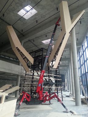 UNIC crane lifting steel and timber to build tree inside museum