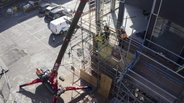 UNIC URW-506 Mini Spider Crane lifting glass.