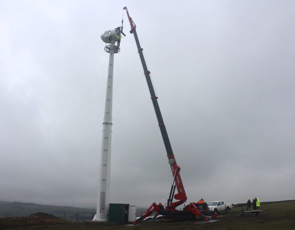A UNIC URW-1006 Mini Spider Crane installing a wind turbine.
