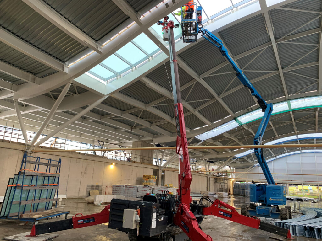UNIC URW-506 Mini Spider Crane and GL-UMC 600 Glass Manipulator install glass roof panels for Wimbledon tennis club.