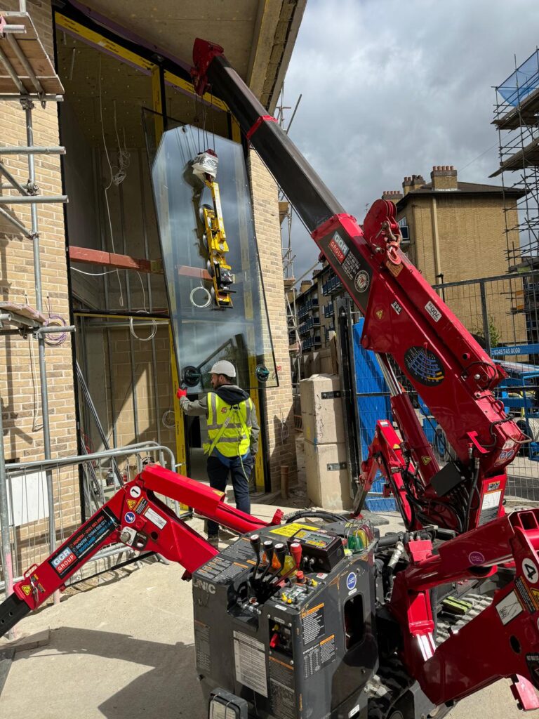 UNIC URW-295 Mini Spider Crane installing curtain walling glazing in London.