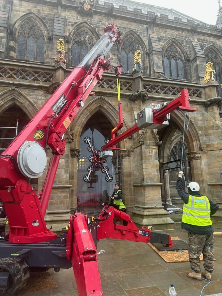 UNIC URW-706 Mini Spider Crane lifting glazing for archway reveals at Rochdale Town Hall.