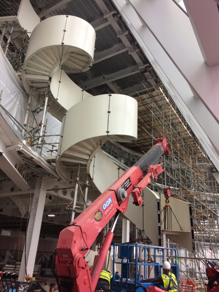 UNIC URW-706 Mini Spider Cranes tandem lifting a staircase for a telecommunications company.