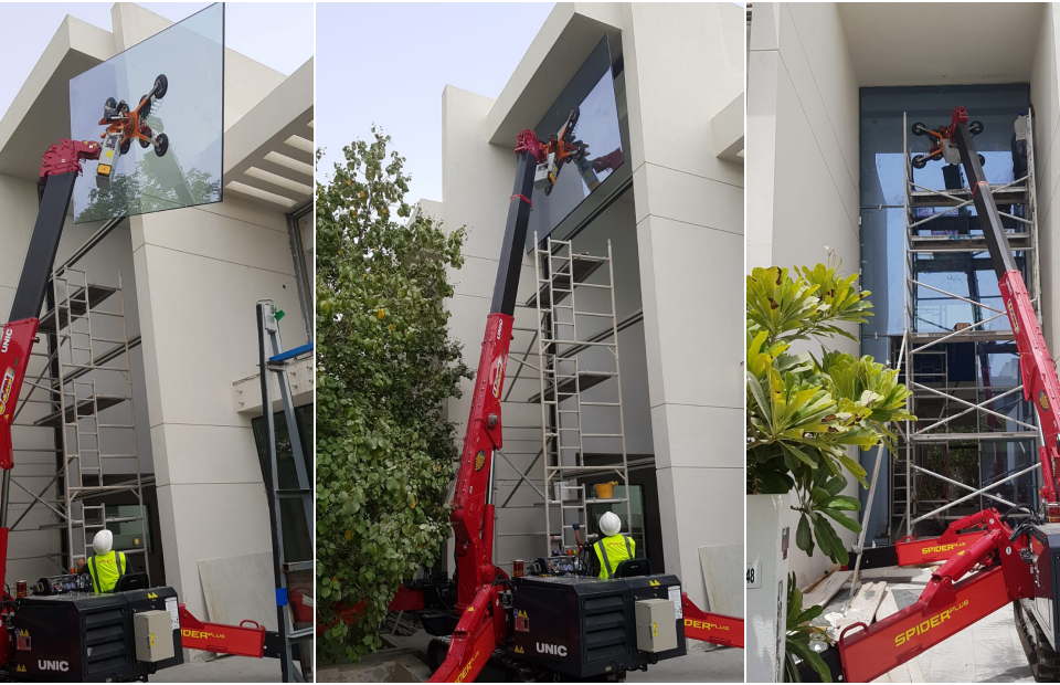 A URW-546 Mini Spider Crane installing glass with the GL-UMC 600 Glass Manipulator in Dubai by UNIC Cranes Europe's dealer Spider Plus.
